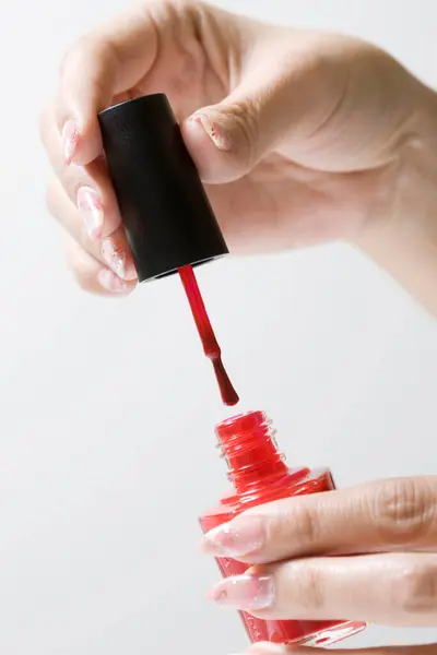 Manos Femeninas Aplicando Esmalte Uñas Rojo Sobre Fondo Blanco —  Fotos de Stock