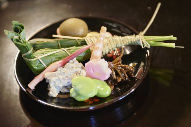 Geleneksel Japon aperatifleri siyah tabakta servis edilir.