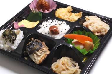 İçinde pirinç balığı turşusu sebze yumurta salatası olan çeşitli Japon bento kutuları.
