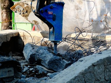 İnşaat alanında yıkılan binalarla çalışan ağır endüstriyel makineler.           