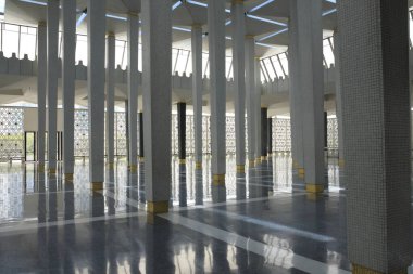 Uzun sütunlar ve yansıtıcı zemin içeren modern mimari