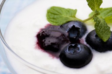 Yoğurtlu yaban mersini ve bardakta nane yaprağı.