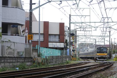 Şehir treni konut binalarının yakınından tren geçidine yaklaşıyor.