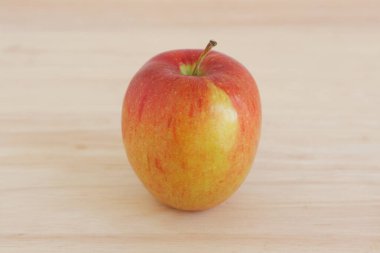 Tahta masa arkasındaki taze elma meyvesinin yakın plan görüntüsü.        