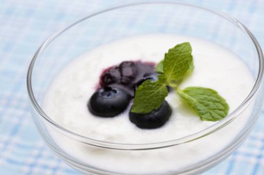 Yoğurtlu yaban mersini ve bardakta nane yaprağı.