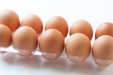 Plastik kabın içinde kahverengi tavuk yumurtaları