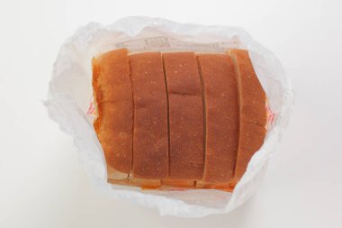 Beyaz arka planda plastik poşette taze ekmeğin üst görüntüsü