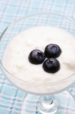 Yoğurt kabuğu. Bardakta taze yaban mersini.