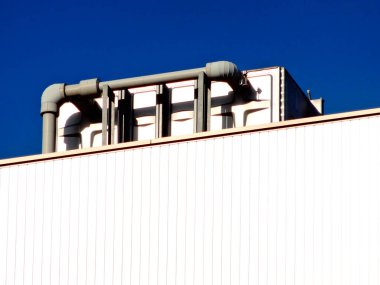 Mavi gökyüzüne karşı endüstriyel yapı ve çelik borular