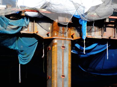 Kapatılan sütunları ve koruyucu materyalleri gösteren inşaat alanı