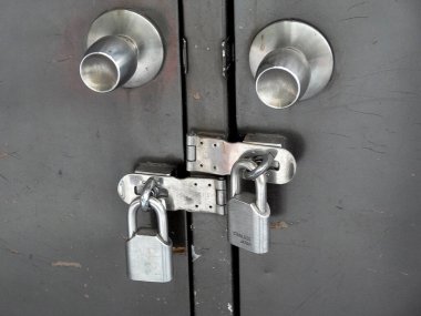 Metal kapı iki asma kilit ve sağlam mandalla korunuyor.