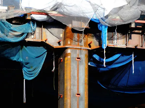 Kapatılan sütunları ve koruyucu materyalleri gösteren inşaat alanı