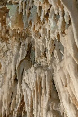Mağara ve doğal oluşumlar, sakin manzarayla çerçevelenmiştir.