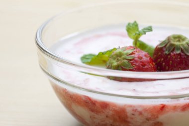 Yoğurtlu ve taze çilekli cam kasede lezzetli bir tatlı.           