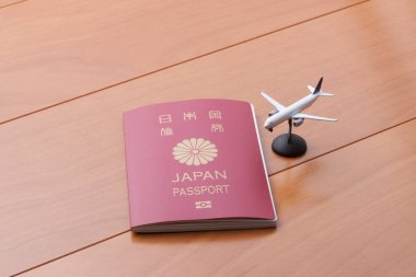 Japonya pasaportu ve uçak modeli masada. 