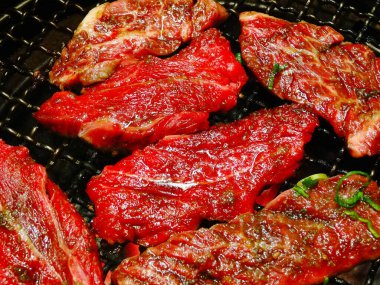 Izgarada pişen taze etin yakın plan görüntüsü.       