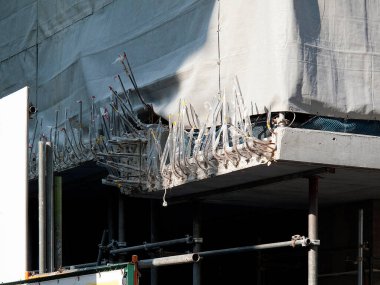 Tamamlanmamış binanın etrafındaki iskeleler koruyucu beyaz muşambayla kaplı.