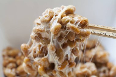 Yapışkan ve yapışkan Natto. Mayalanmış soya fasulyesinden yapılan sağlıklı geleneksel Japon yemekleri..
