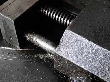 Yakından bakınca metal mengenenin parlak silindirik çubuğu sıkıca kavradığını görüyoruz.