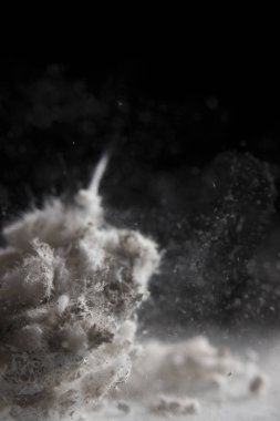 Siyah arka planda beyaz toz patlaması. Renkli bulut. Beyaz toz patlar. Boya deliği.