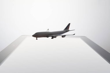 Tablet bilgisayarın üstündeki beyaz uçak kapat