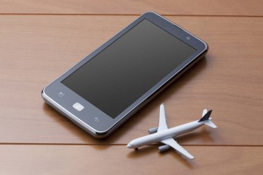 Oyuncak uçak ve akıllı telefon masada.