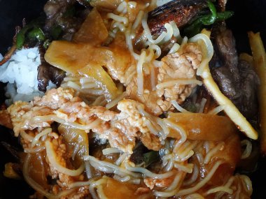 Yakın plan, haşlanmış sebzeleri, buğulanmış pirincin üstünde yumurta bifteğini gösteriyor.