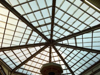 Kesişen metal kirişleri içeren geometrik cam tavan yapısı