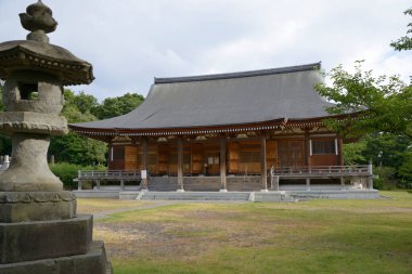 Bulutlu bir günde güzel antik Japon türbesinin manzaralı görüntüsü.