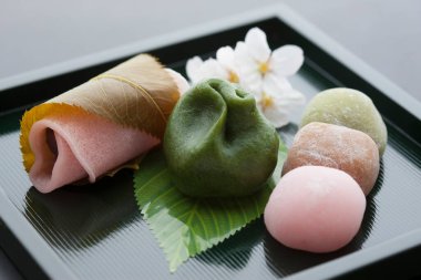 Kiraz çiçeklerinin ve Japon geleneksel tatlılarının yakın görüntüsü, mochi tatlısı.