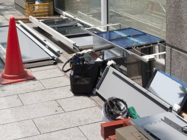 Güneş panelleri bakım sırasında binanın yanındaki kaldırımda yatar.