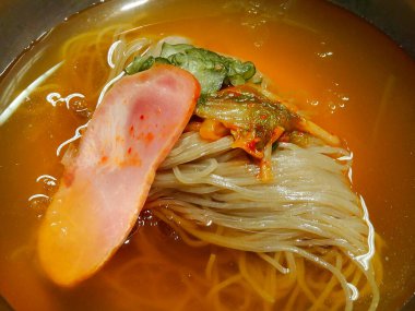 Etli, sebzeli ve erişteli leziz bir Asya yemeğinin kapağını kapat.