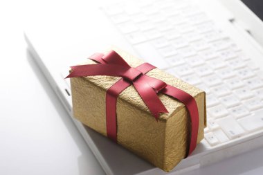 Arkaplanda dizüstü bilgisayarı olan hediye kutusu, kapat