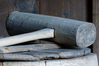 Weathered wooden mallet resting atop rough circular chopping block