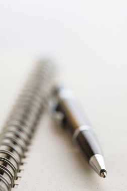 Beyaz arkaplanda kalem ve defter, kapat