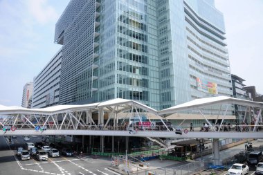 Osaka İstasyonu yakınlarındaki yaya köprüsü ve modern cam binaları kapsıyor.