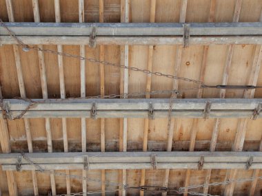Görünür metal çubuklu ahşap kirişler kırsal tavan yapısını destekliyor
