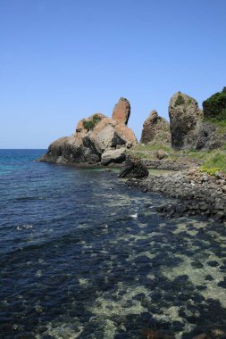Güneşli bir günde kayalık sahil manzarası ve uçurumlar               