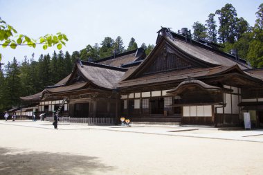 Geleneksel Japon mimari öğeleriyle tapınak binasını ziyaret eden insanlar