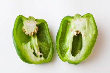 Beyaz arka planda dilimlenmiş yeşil biber.