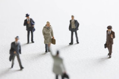 Minyatür insanlar. Meşgul işadamları beyaz arka planda yürüyor