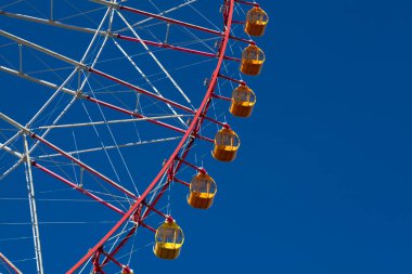 Dönme dolap mavi gökyüzü karşı eğlence parkı içinde             