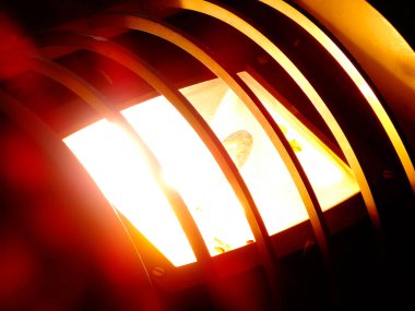 Geceleri metal parmaklıklarda parlayan parlak sokak lambaları.