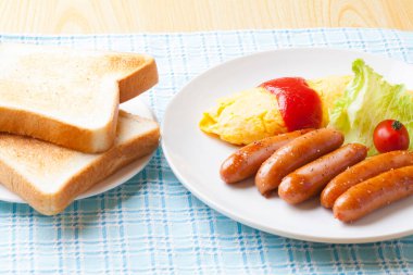 Sosisli kahvaltı, tost, omlet, ketçap, marul ve domates.