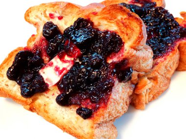 Erimiş tereyağı ve böğürtlen reçeli ile kaplı kızarmış ekmek dilimleri.