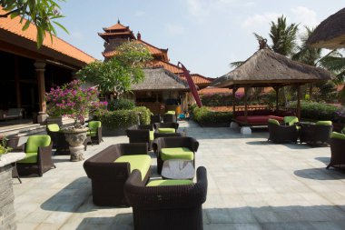 Tropikal bitki ve mimari ile çevrili açık hava oturma alanı