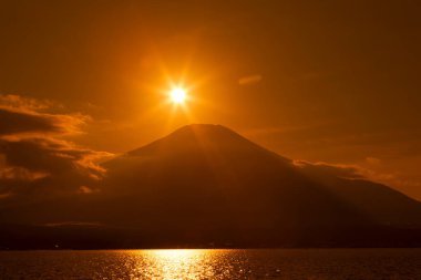 Japonya 'daki gölden Fuji Dağı' nın üzerinde güzel bir günbatımı.