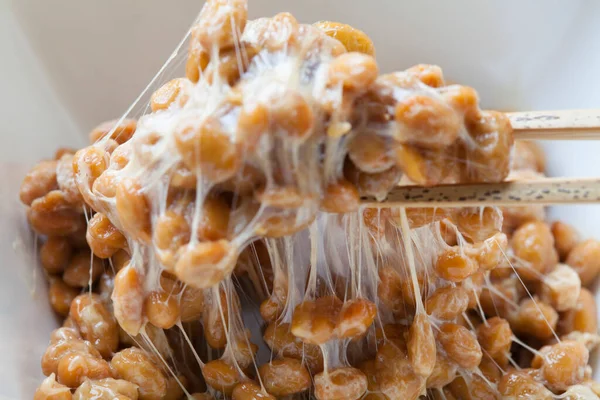 Yapışkan ve yapışkan Natto. Mayalanmış soya fasulyesinden yapılan sağlıklı geleneksel Japon yemekleri..