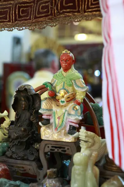 Süslü bir tapınakta Kırmızı Yüzlü ve Yeşil Kaftanlı Küçük Çin İlahı Heykeli