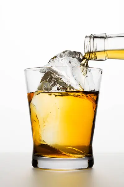 Widok Bliska Nalewanie Alkoholu Butelki Szklanki Kostkami Lodu Białym Tle — Zdjęcie stockowe